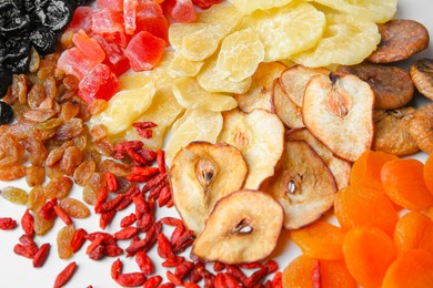 Pile of different tasty dried fruits on white background, above view