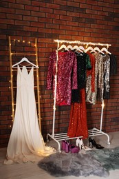 Photo of Collectiondifferent beautiful women's party dresses and shoes in showroom. Stylish trendy clothes for high school prom