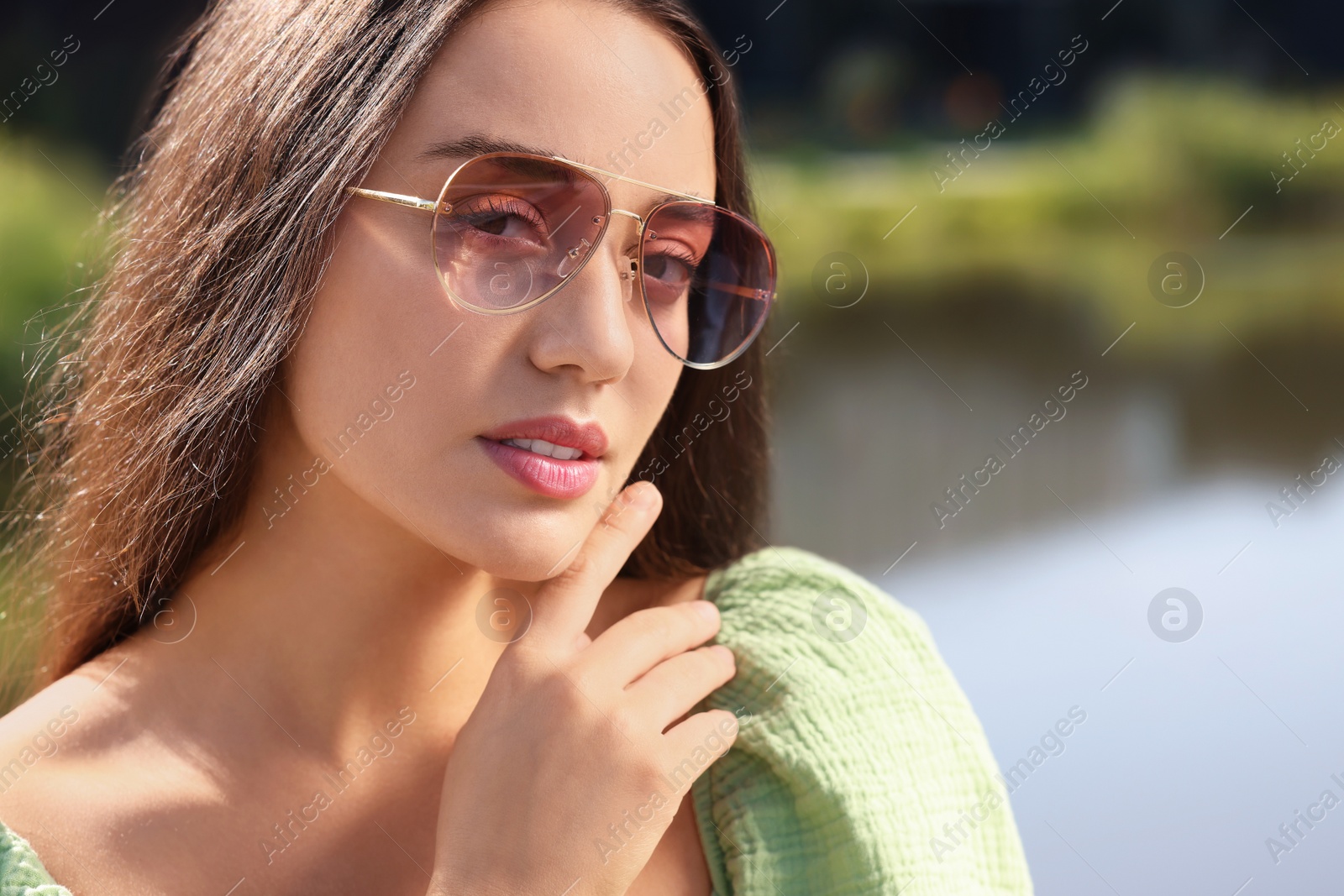 Photo of Beautiful woman in sunglasses near river, space for text