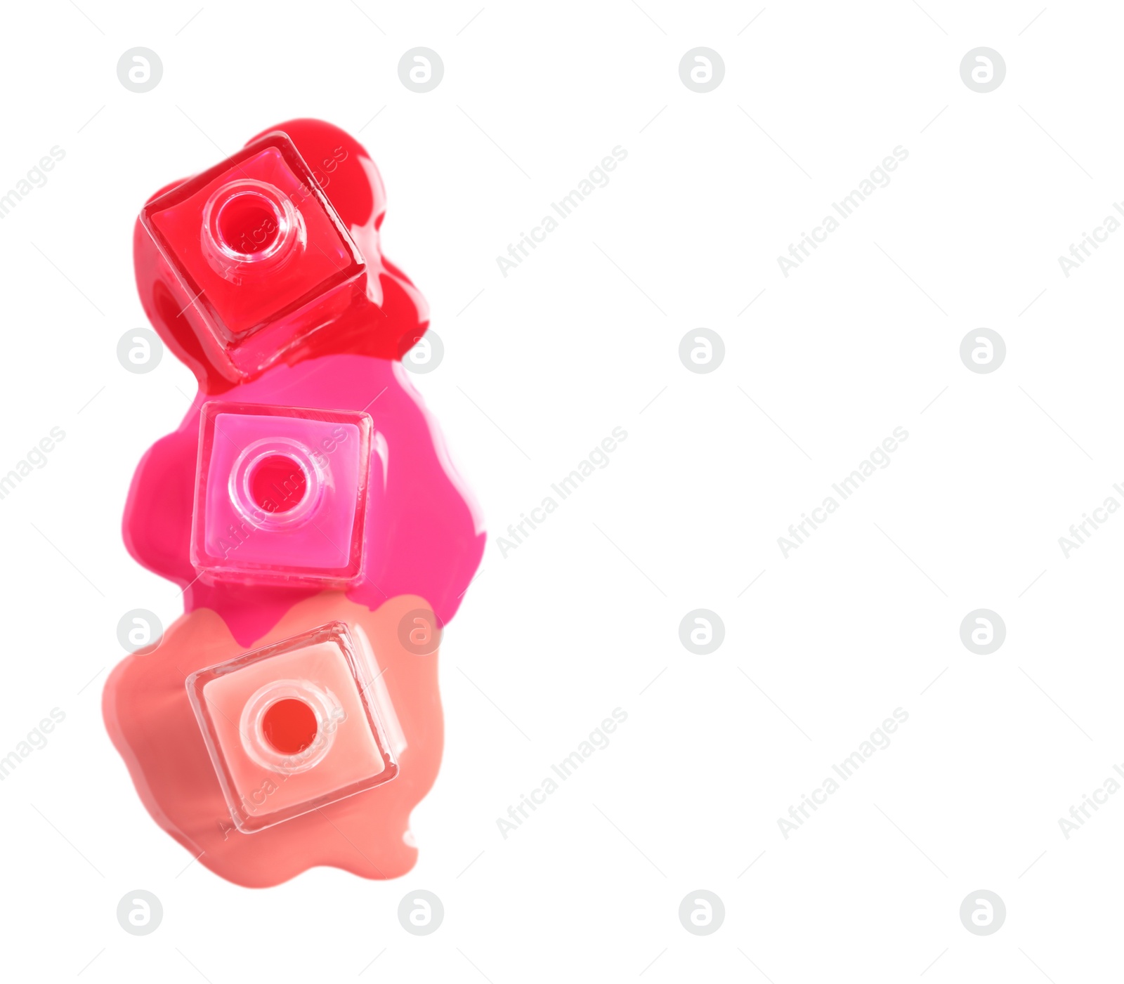 Photo of Spilled different nail polishes with bottles on white background, top view