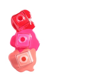 Photo of Spilled different nail polishes with bottles on white background, top view