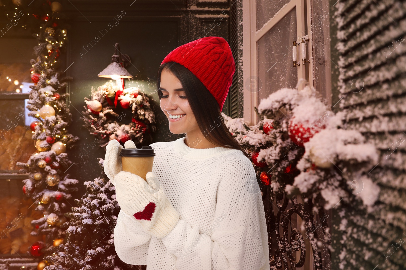 Image of Happy beautiful woman with paper cup of mulled wine at Christmas fair