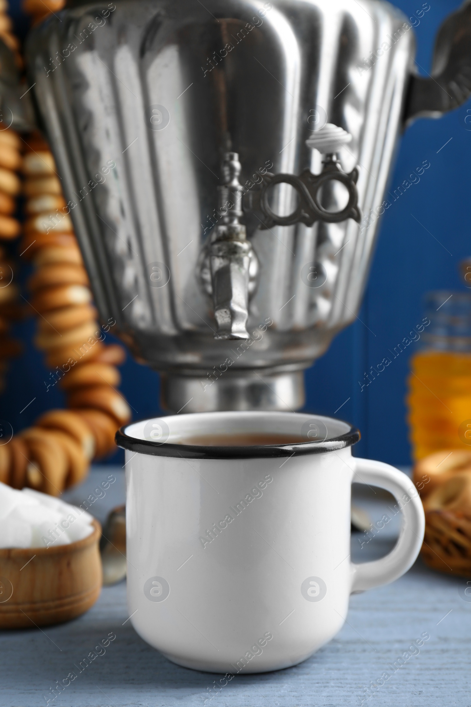 Photo of Mug and samovar on grey wooden table