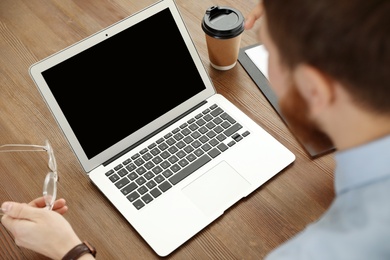 Man using video chat on laptop in home office, closeup. Space for text