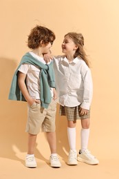 Fashion concept. Stylish children on pale orange background