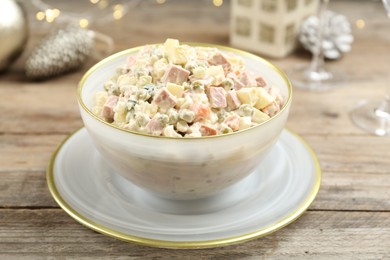 Traditional russian salad Olivier served on wooden table