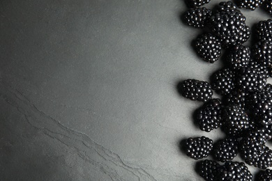 Tasty ripe blackberries on slate plate, top view with space for text