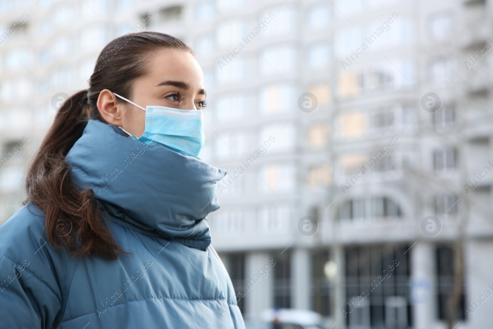 Photo of Woman wearing disposable mask outdoors. Dangerous virus