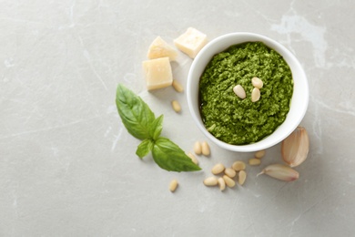 Photo of Composition with bowl of tasty pesto sauce on grey table, flat lay. Space for text