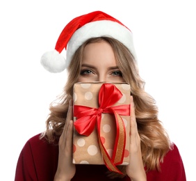 Happy young woman wearing Santa hat with Christmas gift on white background