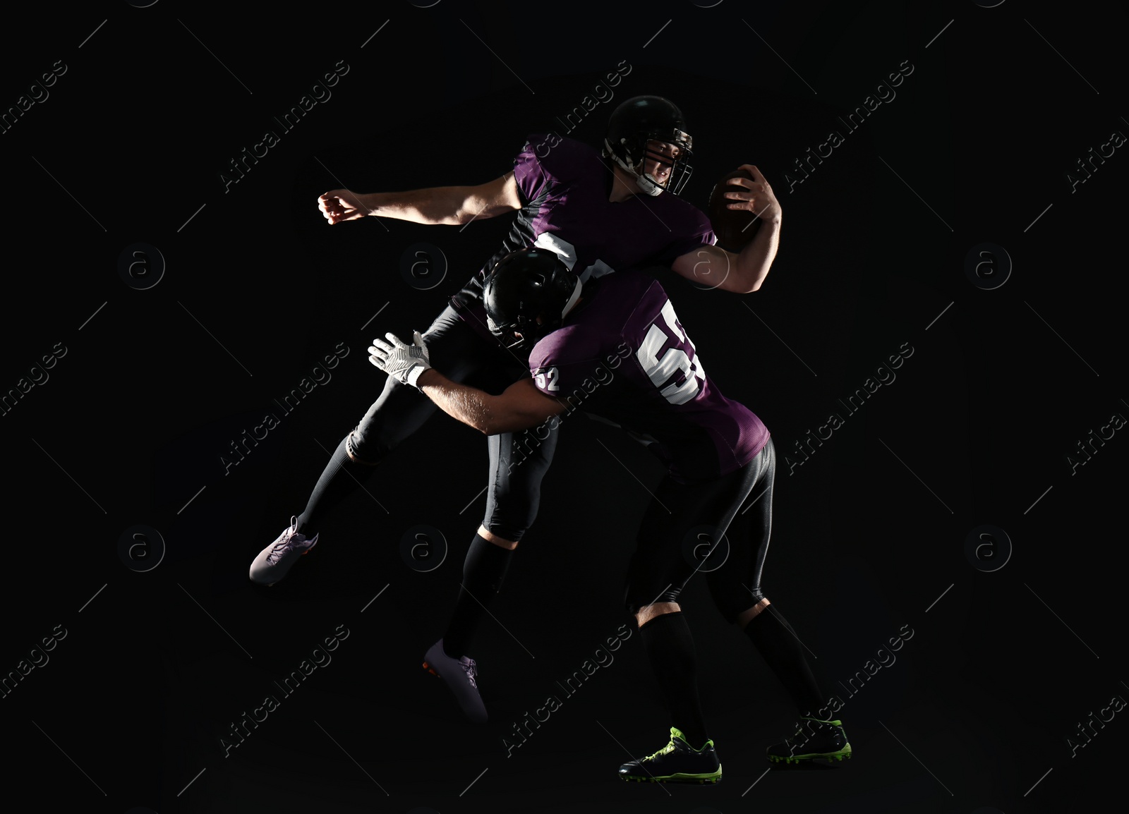 Photo of Men in uniform playing American football on dark background