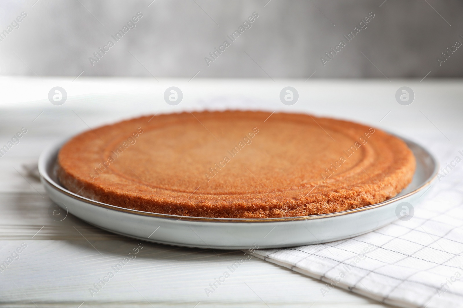 Photo of Delicious homemade sponge cake on white wooden table, closeup