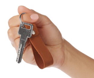 Woman holding key with leather keychain on white background, closeup