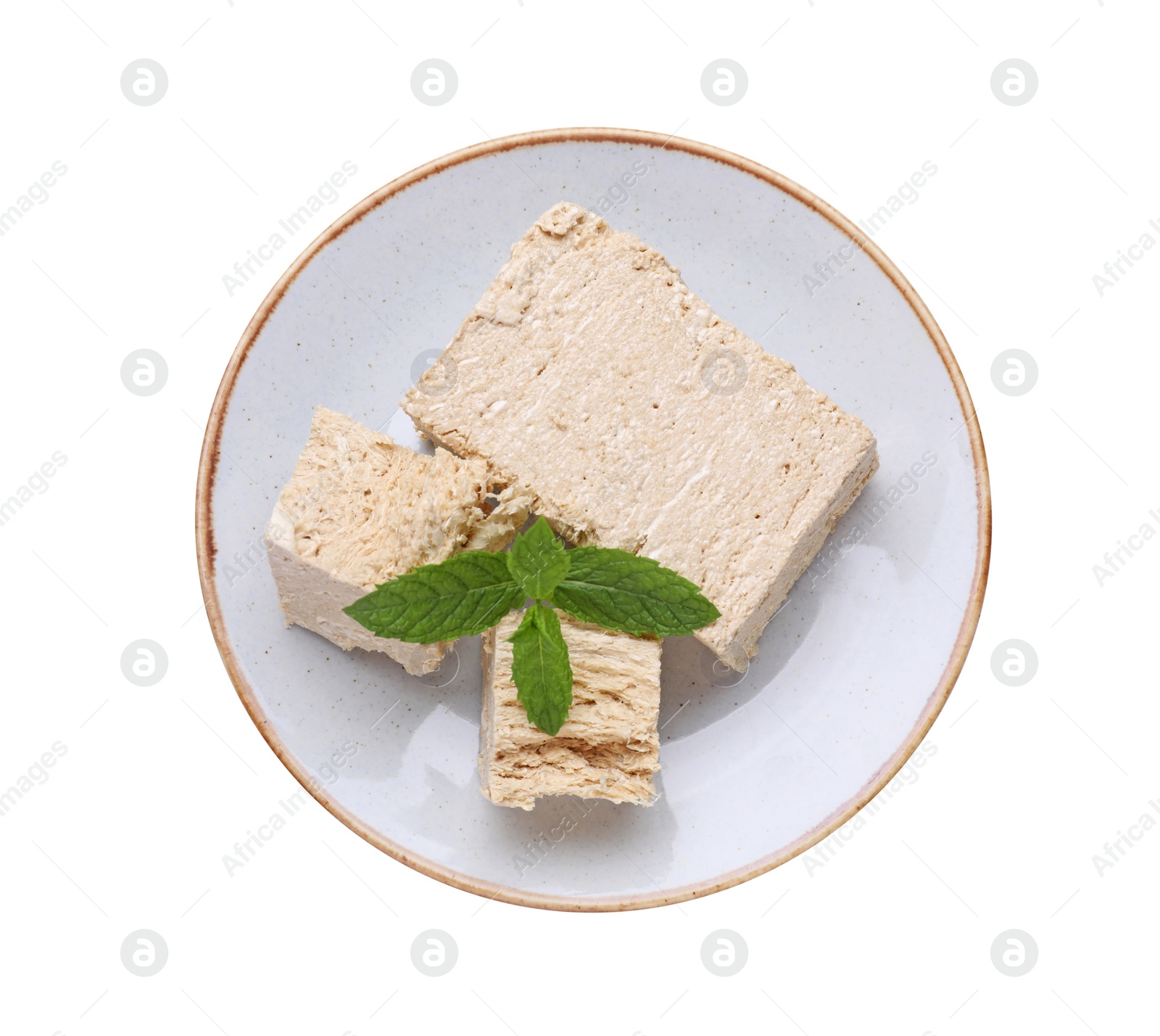 Photo of Plate with pieces of tasty halva and mint isolated on white, top view