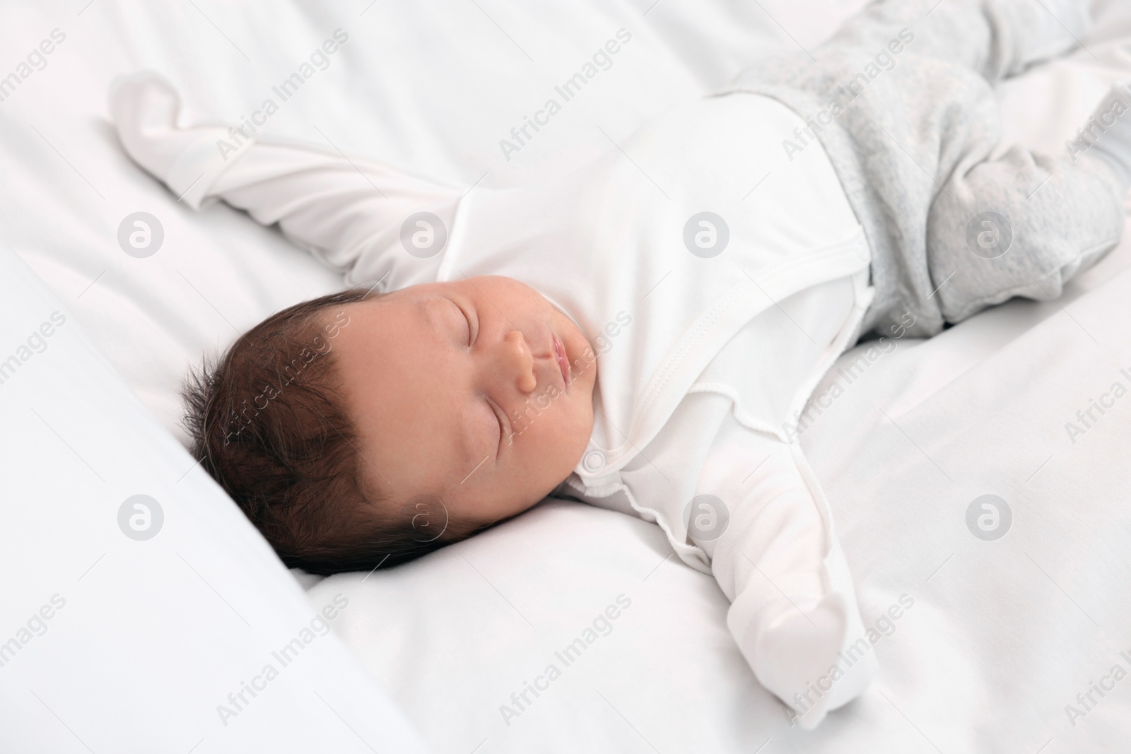 Photo of Cute newborn baby sleeping on white soft bed