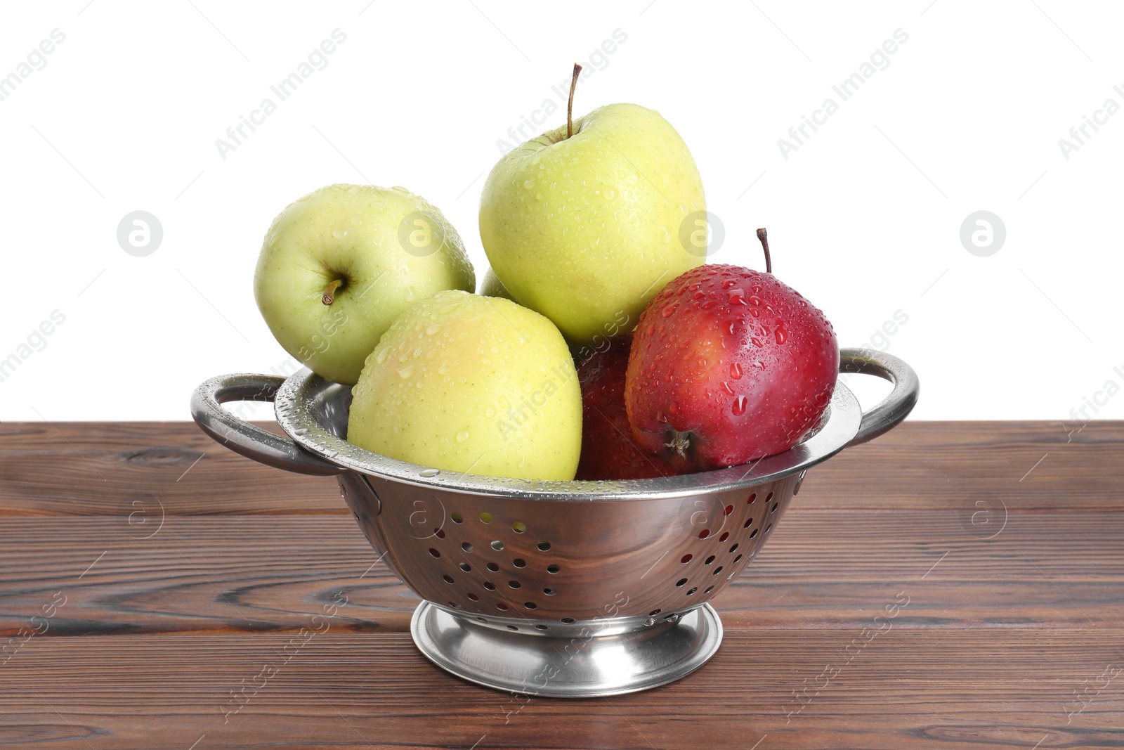 Photo of Metal colander with fresh apples on wooden table against white background