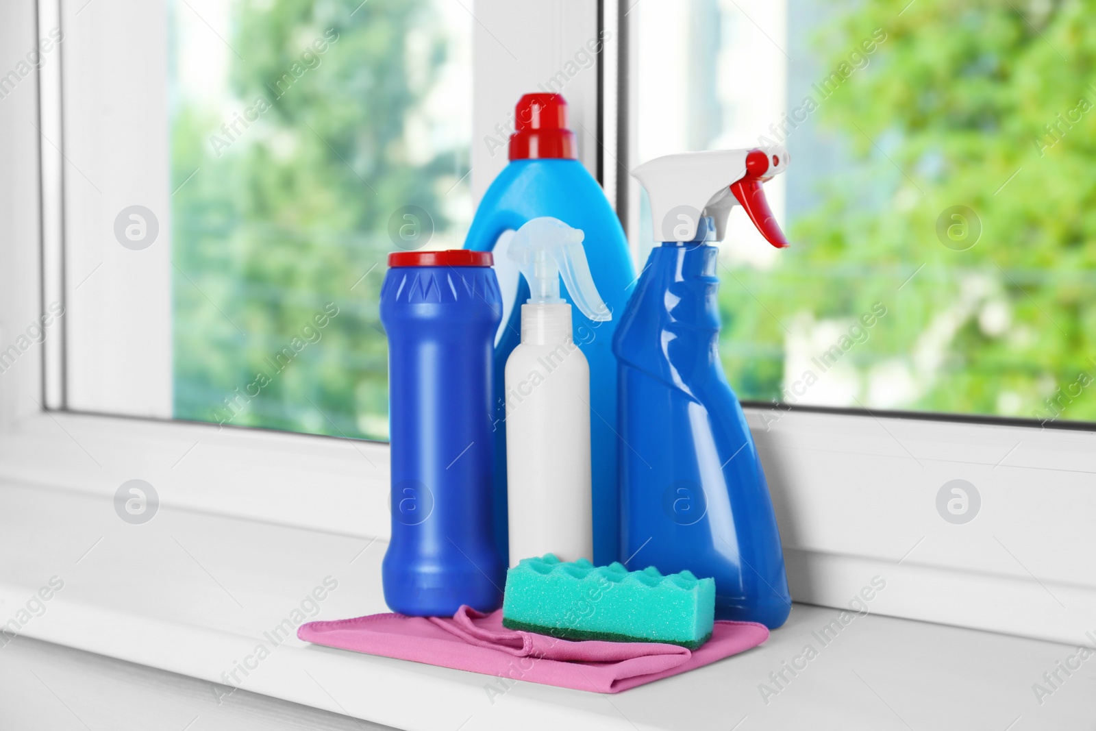 Photo of Different cleaning supplies and tools on window sill indoors