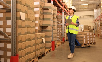 Woman with tablet working at warehouse. Logistics center