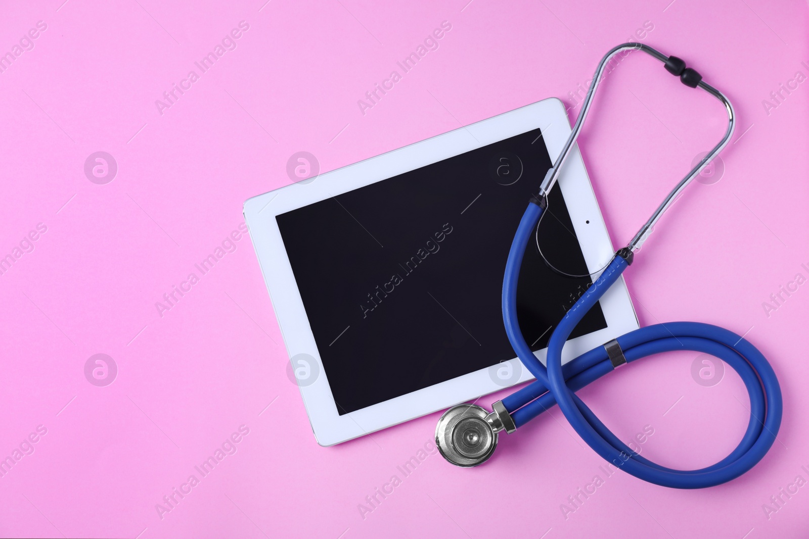 Photo of Flat lay composition with tablet and stethoscope on pink background, space for text. Gynecology concept