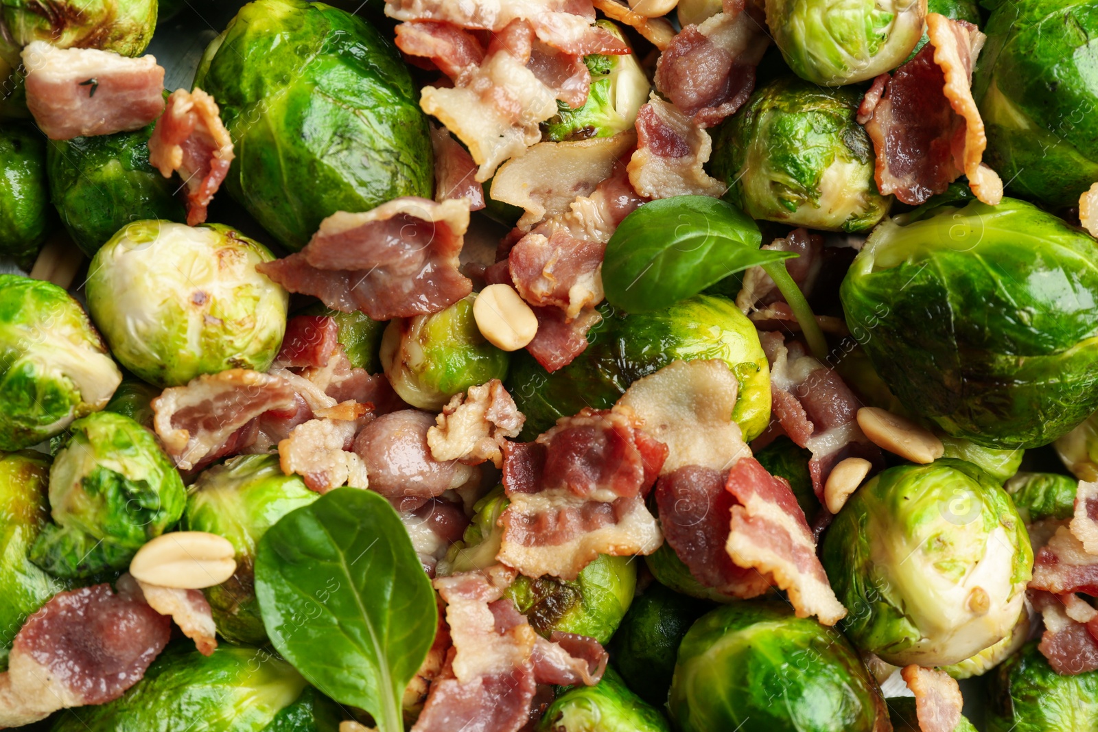 Photo of Delicious Brussels sprouts with bacon as background, top view