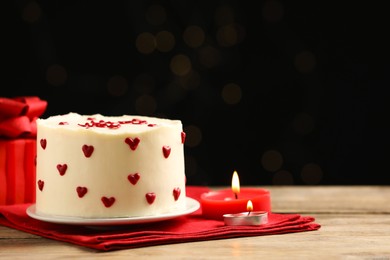 Bento cake, candles and gift box on wooden table, space for text. St. Valentine's day surprise