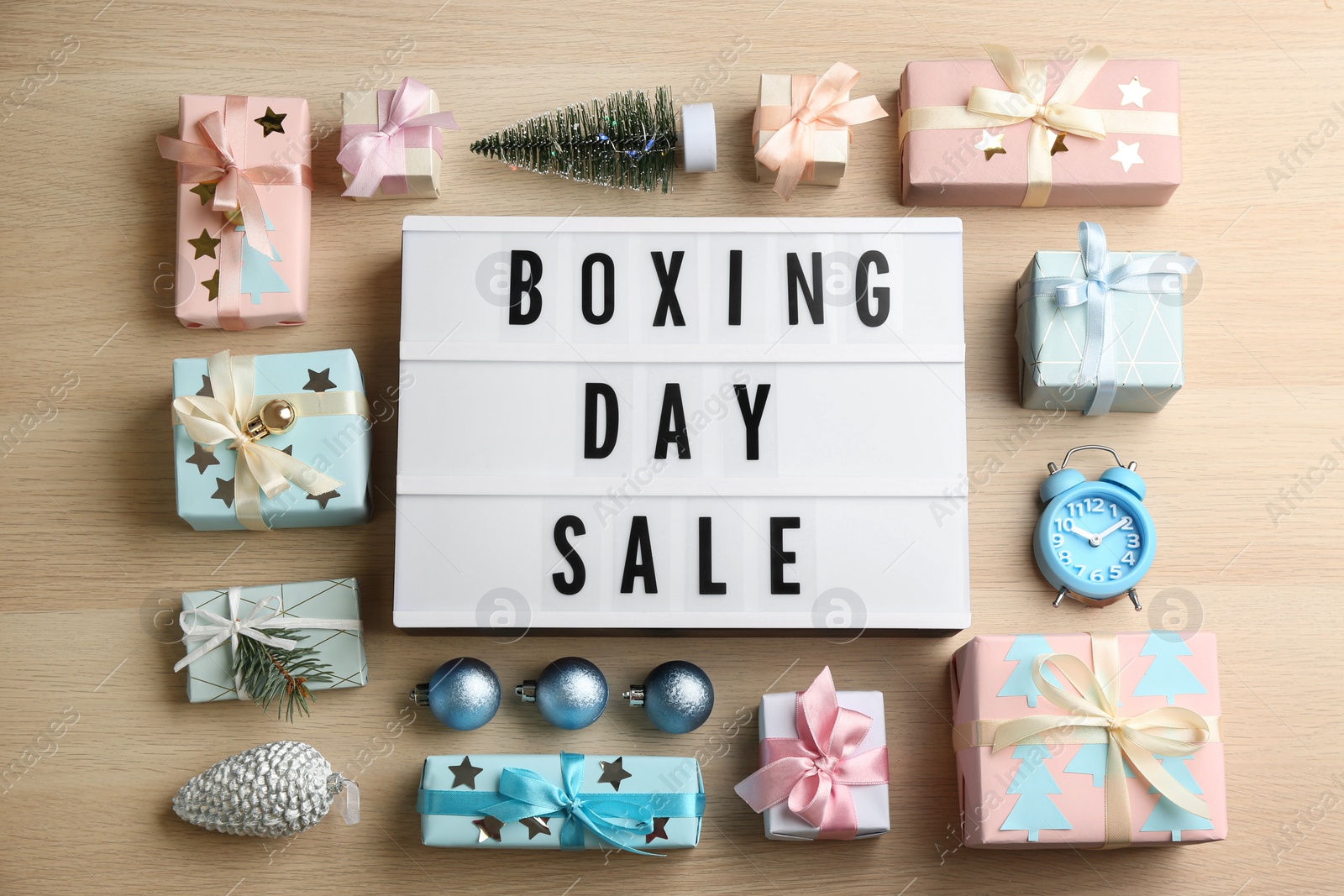 Photo of Flat lay composition with Boxing Day Sale sign and Christmas gifts on wooden table