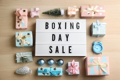 Flat lay composition with Boxing Day Sale sign and Christmas gifts on wooden table