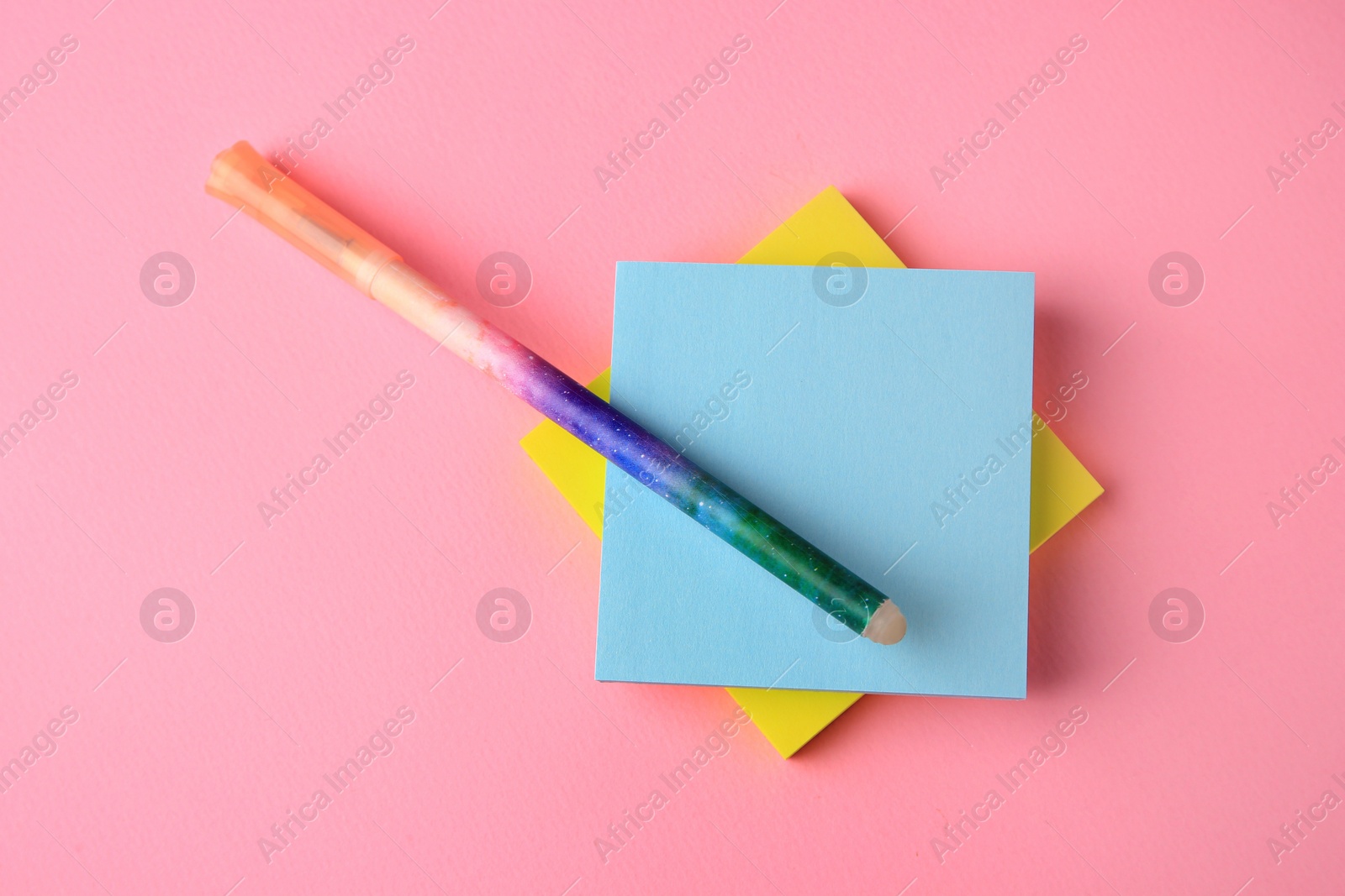Photo of Colorful paper notes with erasable pen on pink background, top view. Space for text