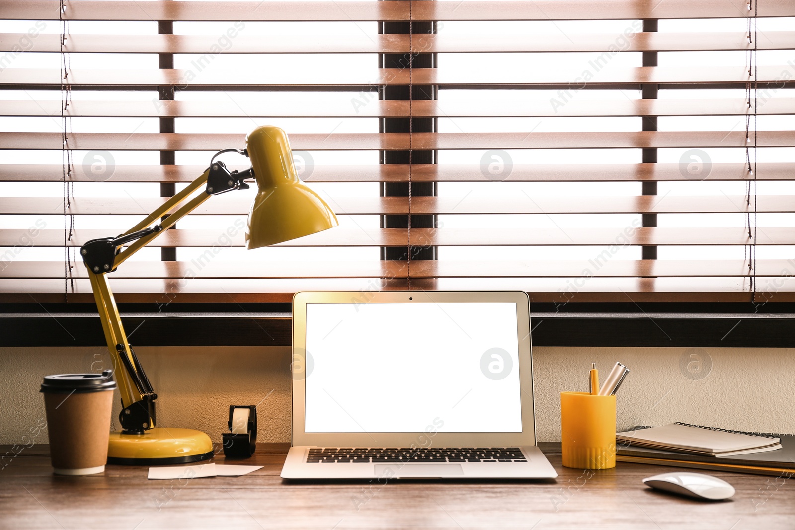 Photo of Modern laptop on table in office. Comfortable workplace