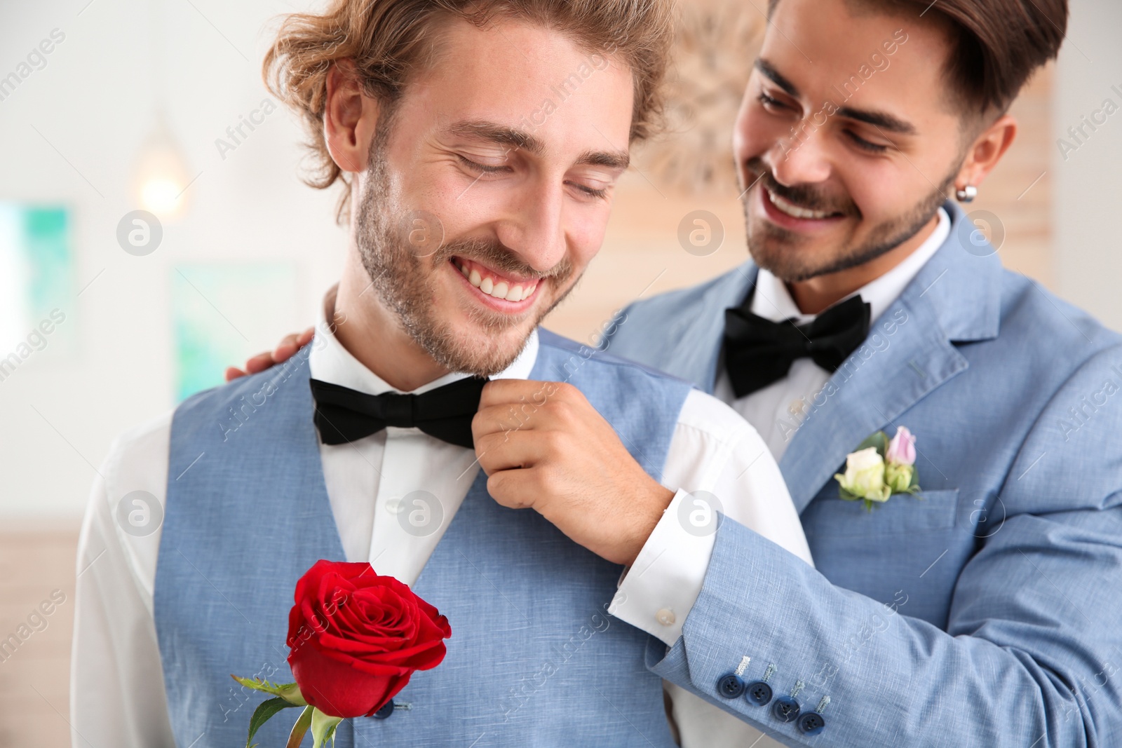 Photo of Happy newlywed gay couple with flower at home