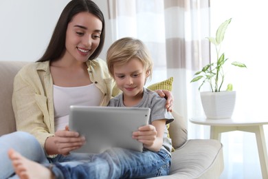 Photo of Mother and son reading E-book together at home