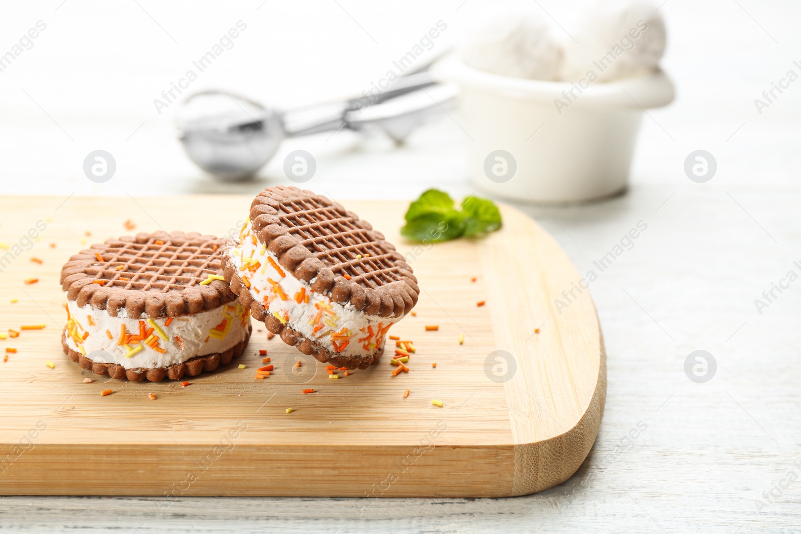 Photo of Sweet delicious ice cream cookie sandwiches on white wooden table. Space for text