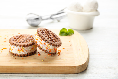 Sweet delicious ice cream cookie sandwiches on white wooden table. Space for text