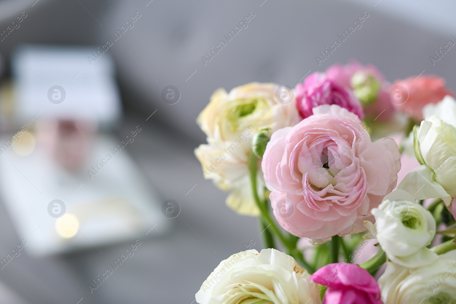 Photo of Bouquet of beautiful ranunculuses on blurred background. Space for text