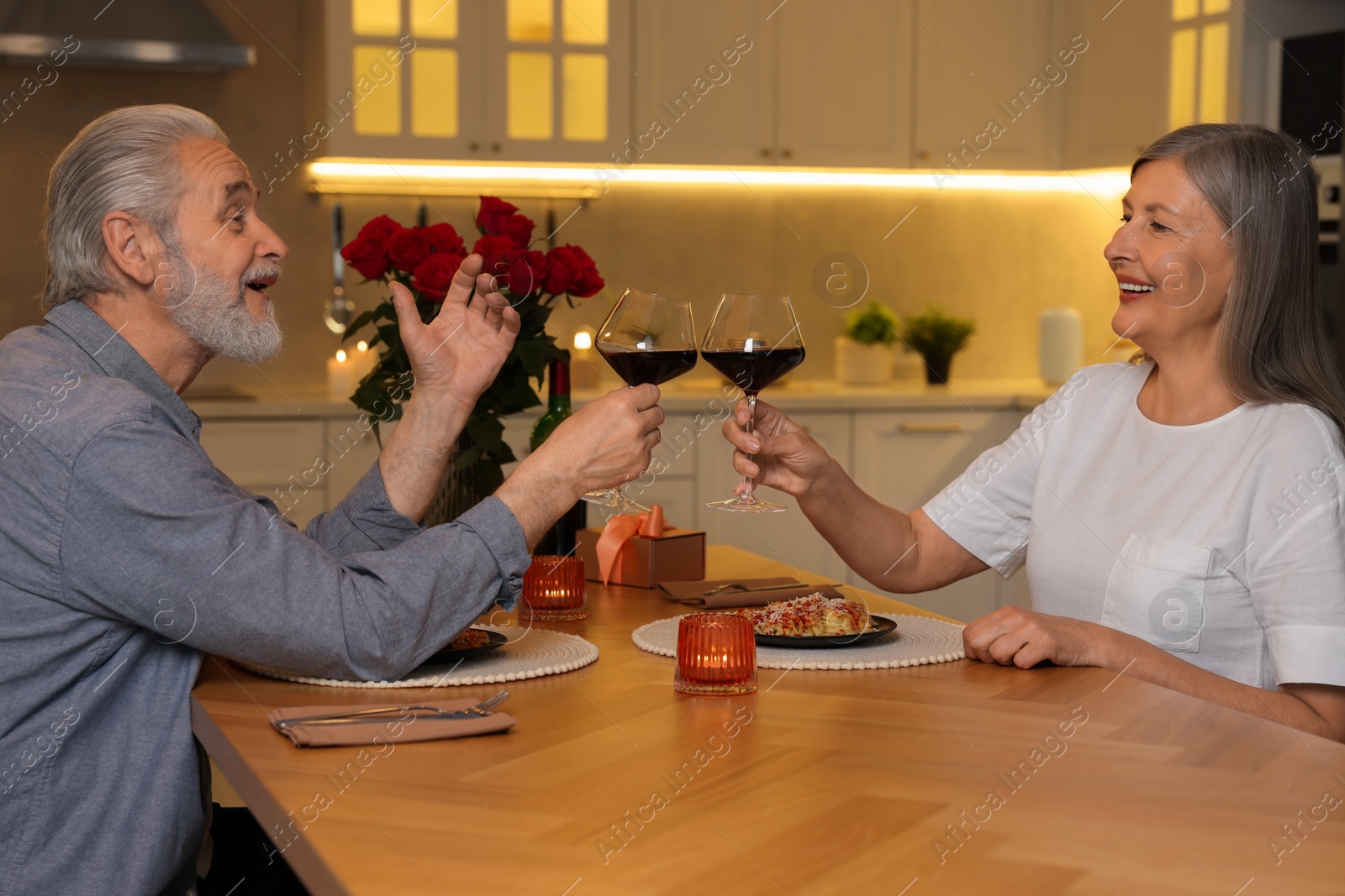 Photo of Affectionate senior couple having romantic dinner at home