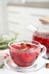 Photo of Tasty hot cranberry tea on white table. Space for text