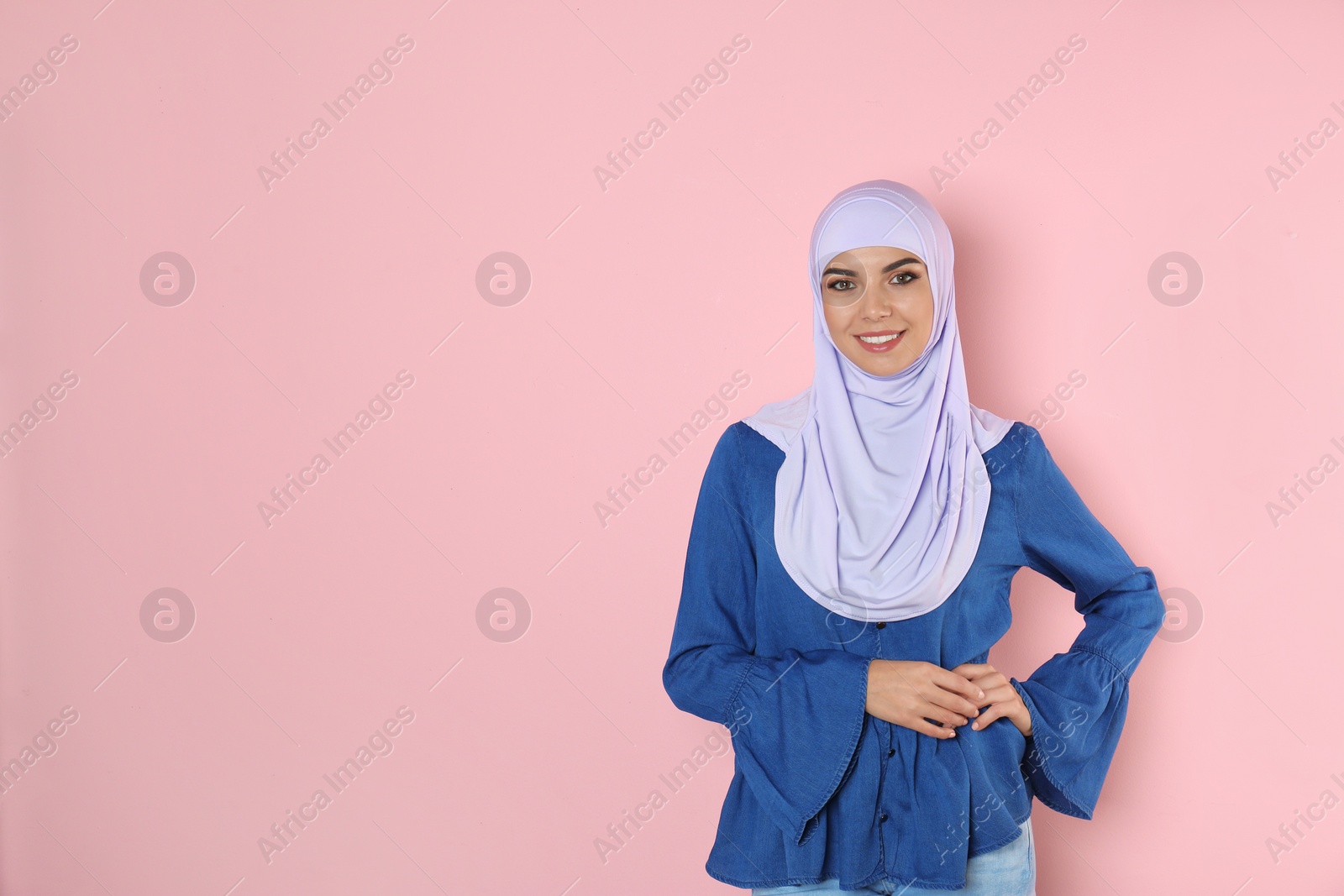 Photo of Portrait of young Muslim woman in hijab against color background. Space for text