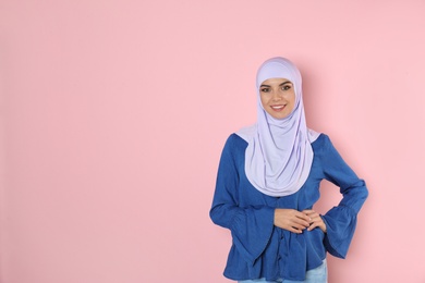 Photo of Portrait of young Muslim woman in hijab against color background. Space for text