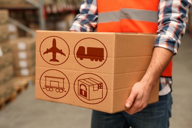 Image of Worker with cardboard box with shipping icons in warehouse, closeup. Wholesaling