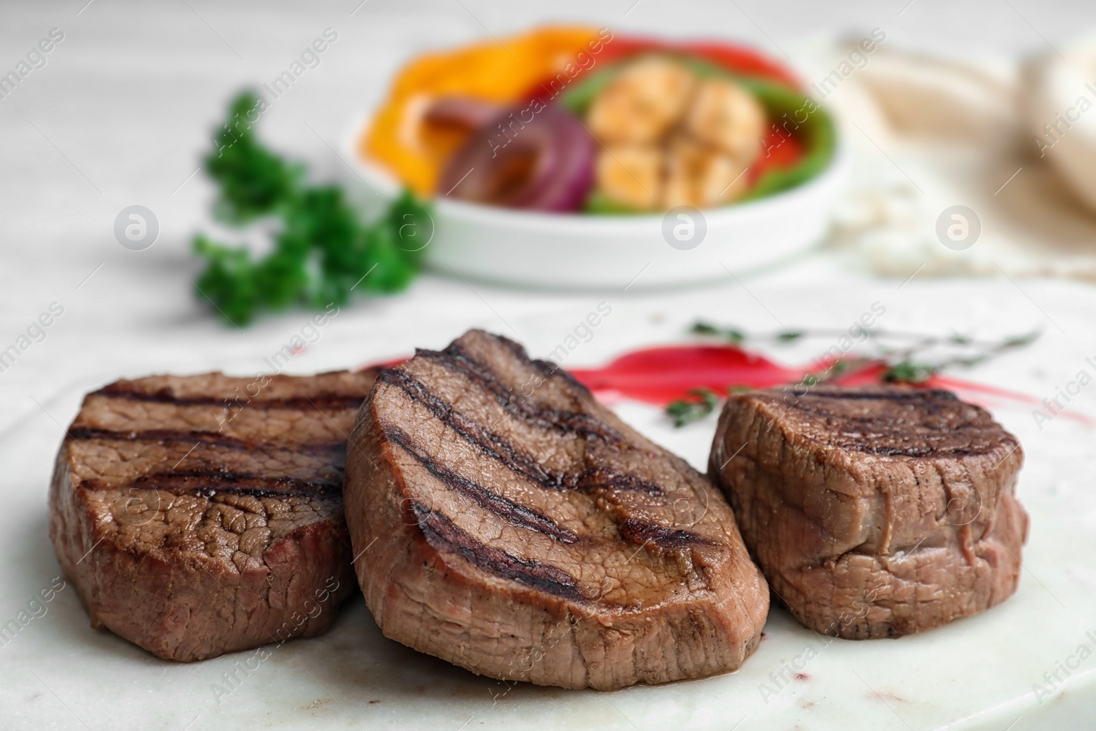 Photo of Stone board with delicious grilled meat on table