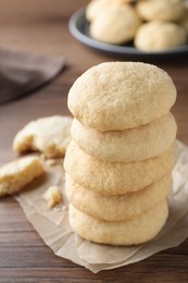 Photo of Stack of tasty sugar cookies on wooden table, closeup