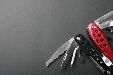 Compact portable multitool on grey background, top view. Space for text