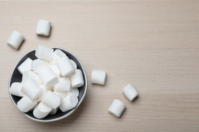 Photo of Delicious puffy marshmallows on wooden table, flat lay. Space for text