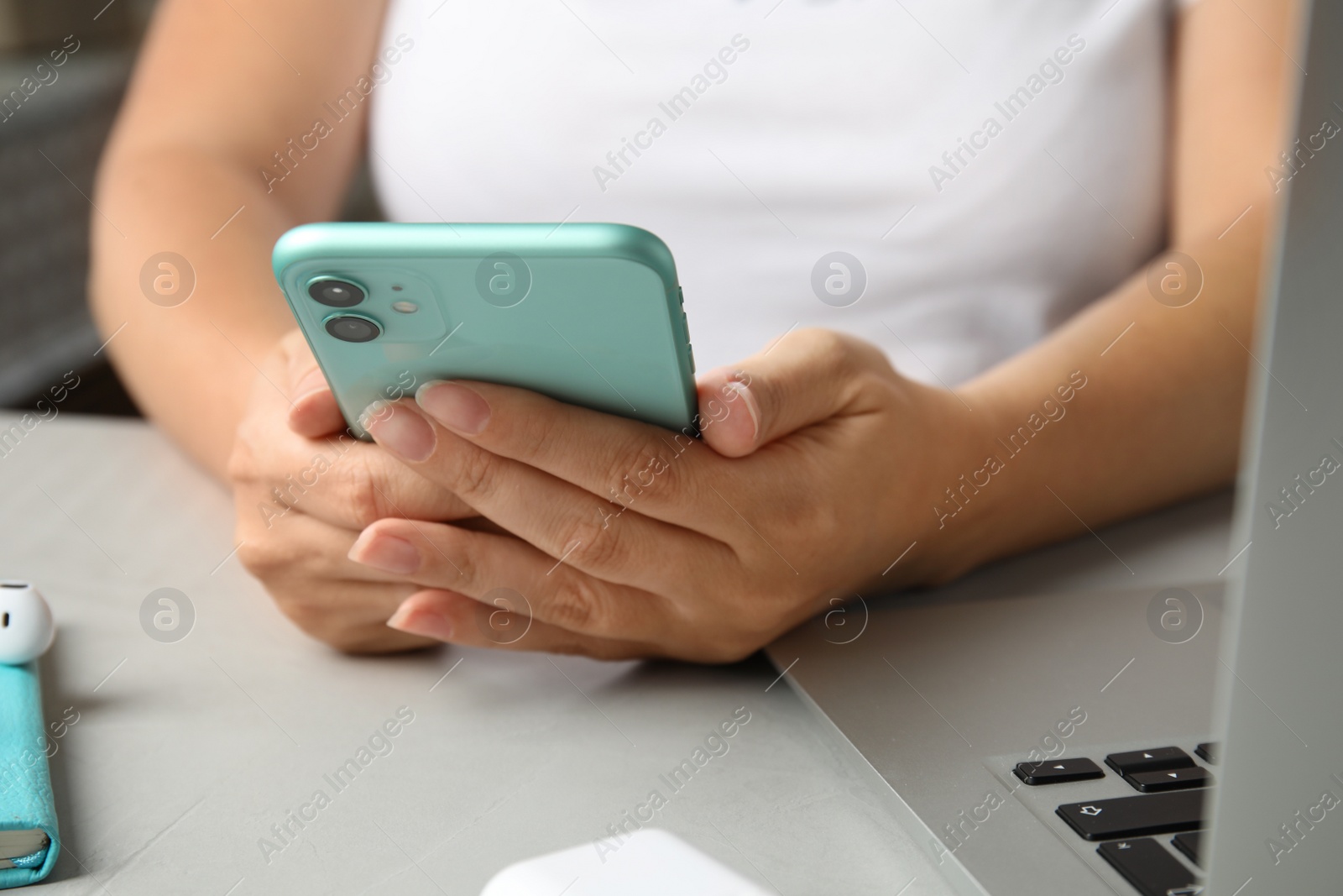 Photo of MYKOLAIV, UKRAINE - JULY 10, 2020: Woman using Iphone 11 Green at table, closeup