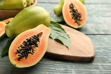 Photo of Fresh ripe papaya fruits on wooden table. Space for text