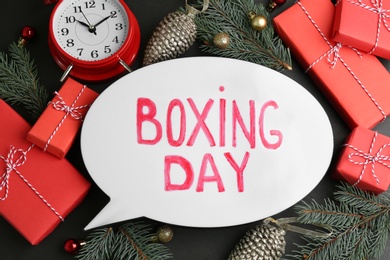 Photo of Flat lay composition with Boxing Day sign and Christmas gifts on black table