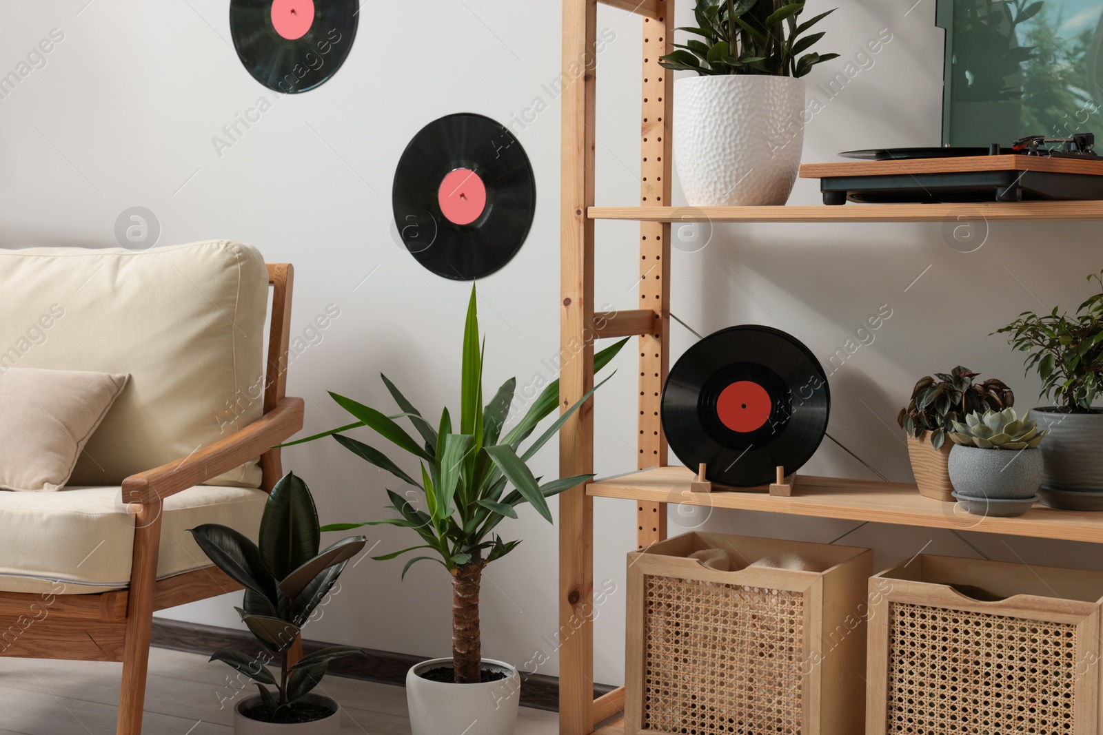 Photo of Living room interior with stylish turntable on wooden shelving unit and vinyl records