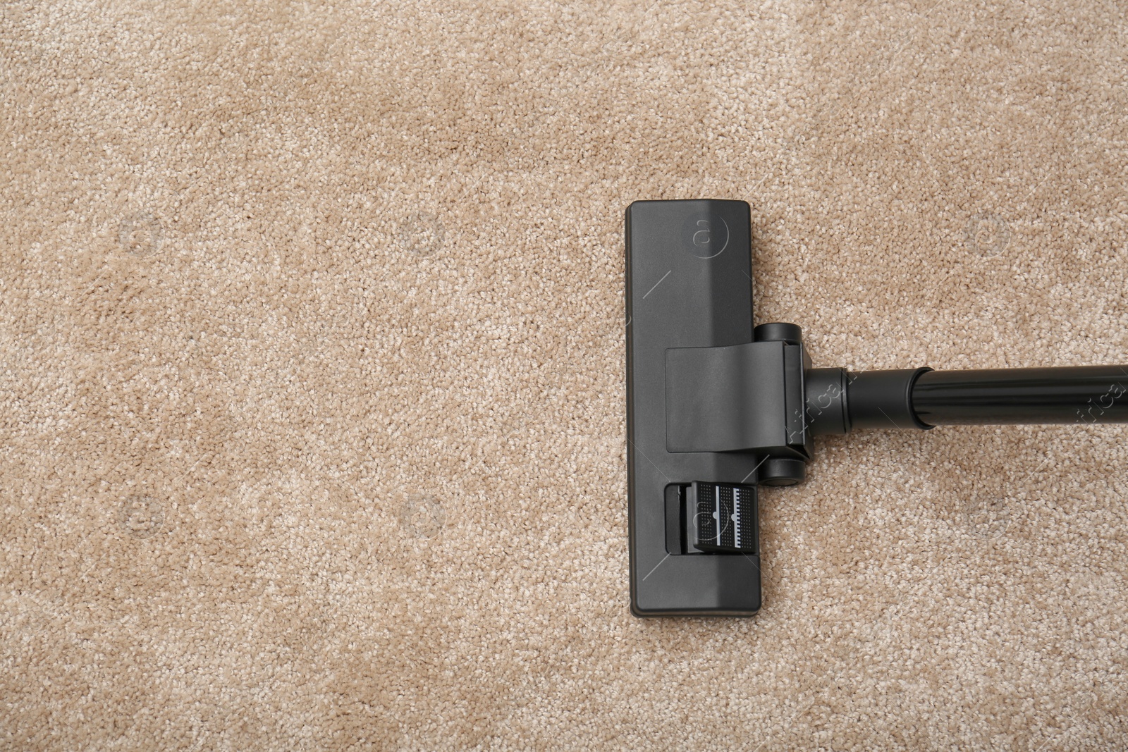 Photo of Removing dirt from carpet with vacuum cleaner indoors, top view. Space for text