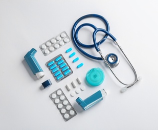 Photo of Flat lay composition with stethoscope and asthma medications on white background