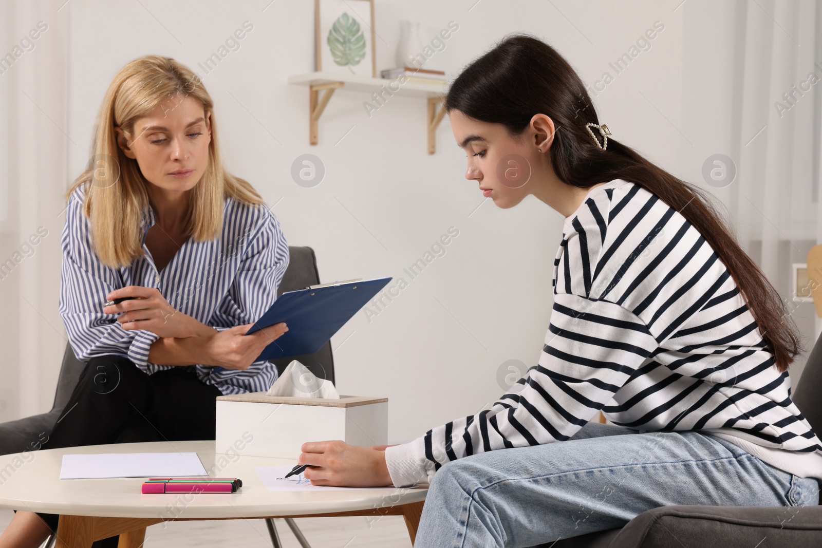 Photo of Psychologist working with teenage girl in office. Teenager problems